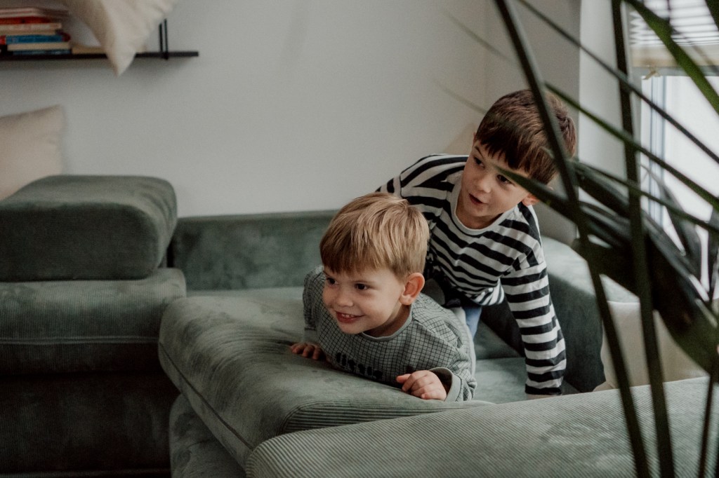 Zwei Kleinkinder auf dem Sofa die gerade observieren