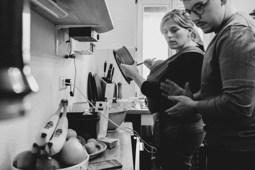 Mann und Frau schauen während sie kochen auf ihr Handy für ein Kochrezept