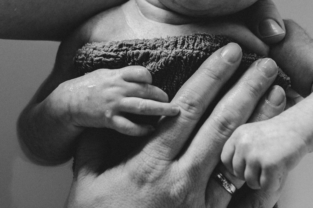 Babyhand greift nach Muttershand