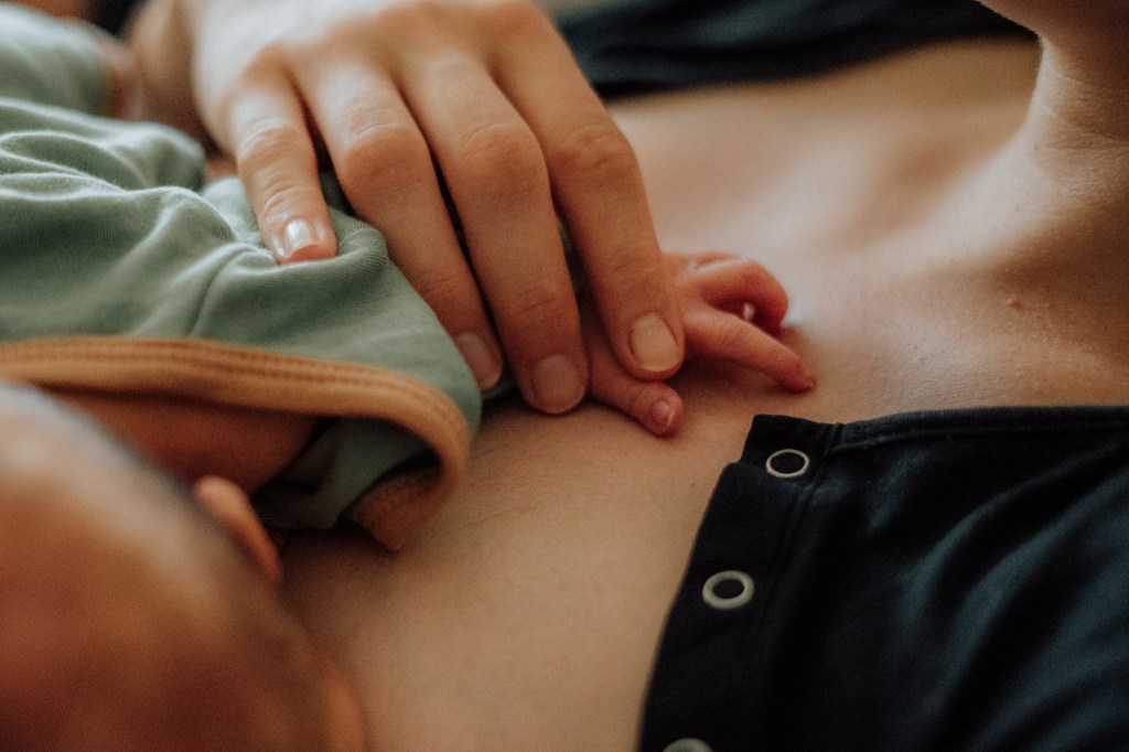 Detailaufnahme Mama hält Hand ihres Neugeborenen fest