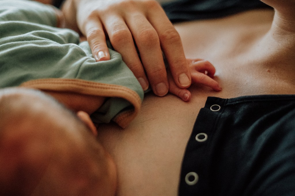 Authentische Wochenbettfotografie in Freiburg: Eine Mutter hält die Hand ihres Neugeborenen im Projekt Mutter werden von Thuy Hang Willmann Fotografie.