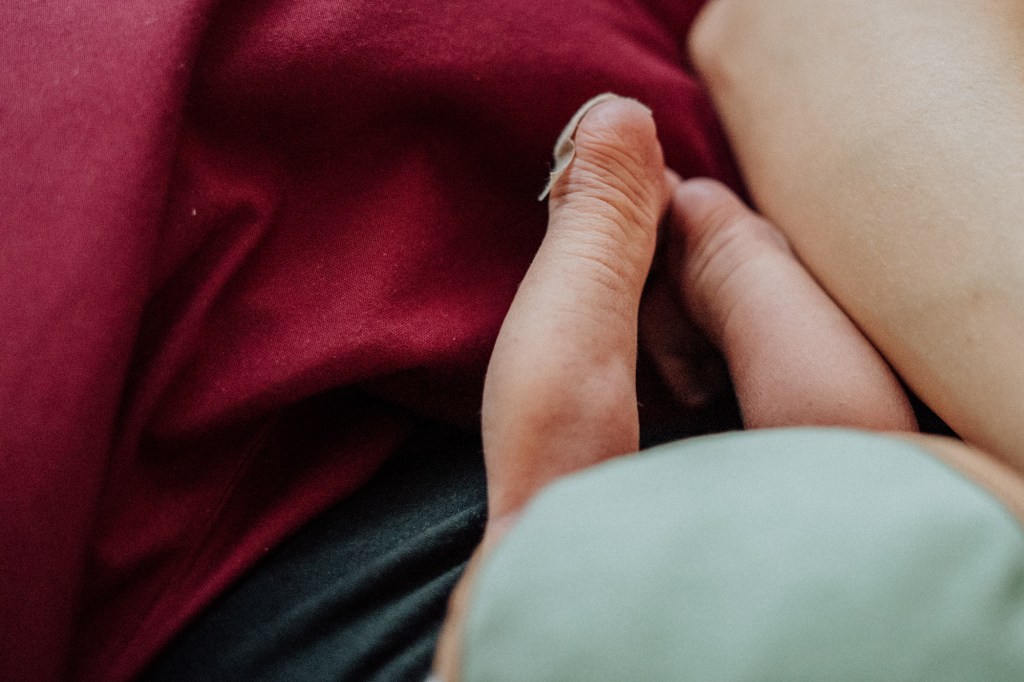 Authentische Wochenbettfotografie in Freiburg: Eine Mutter mit ihrem Neugeborenen im Projekt Mutter werden von Thuy Hang Willmann Fotografie."